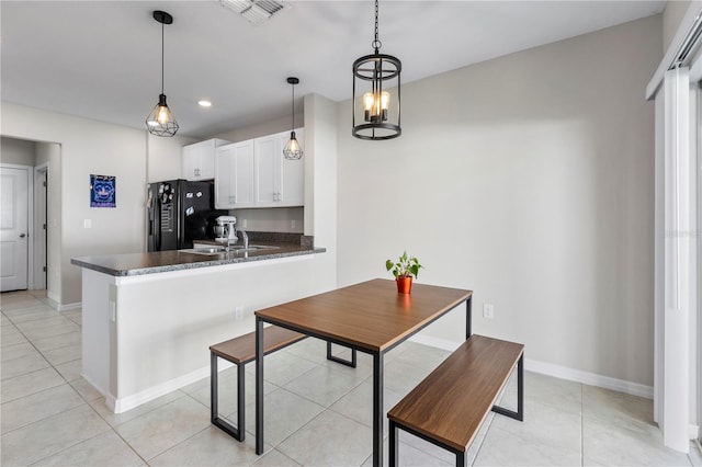 kitchen featuring white cabinetry, kitchen peninsula, decorative light fixtures, and black fridge with ice dispenser