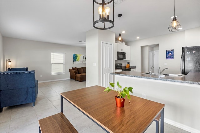 dining space featuring a notable chandelier, sink, and light tile patterned floors