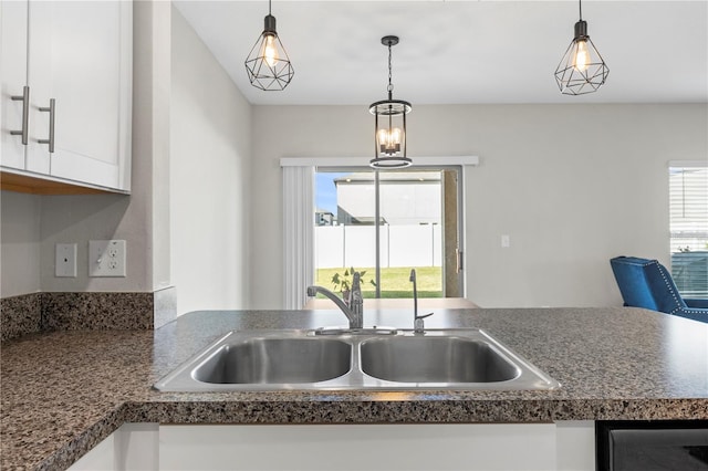 kitchen with white cabinetry, sink, and pendant lighting