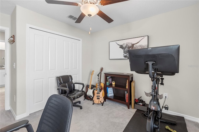 exercise room featuring light carpet and ceiling fan