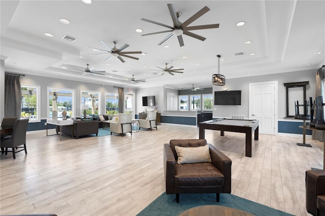 rec room with light hardwood / wood-style flooring and a tray ceiling