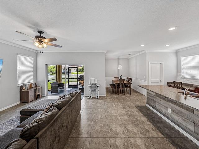 tiled living room with ornamental molding, a textured ceiling, and ceiling fan