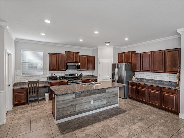 kitchen featuring stainless steel appliances, ornamental molding, sink, and an island with sink