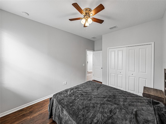 bedroom with a textured ceiling, dark hardwood / wood-style floors, a closet, and ceiling fan