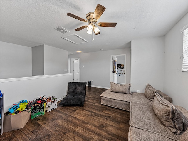 living room with a textured ceiling, ceiling fan, and dark hardwood / wood-style flooring