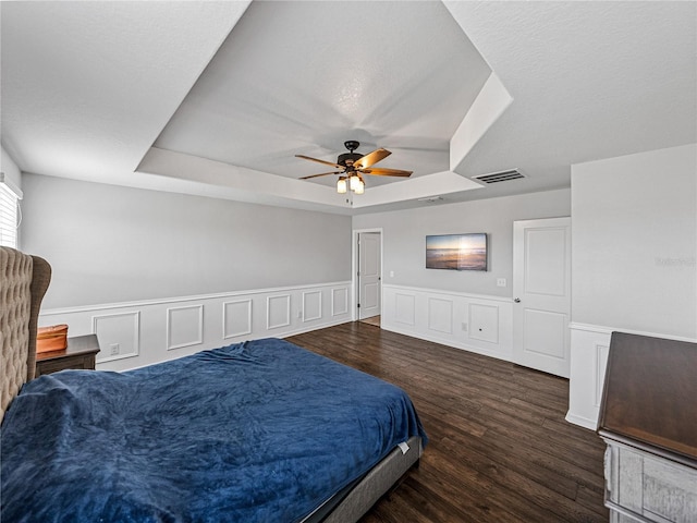 8720 Savory Walk Dr, Land O Lakes, FL 34637 - bedroom with a wainscoted wall, a ceiling fan, wood finished floors, a tray ceiling, and visible vents
