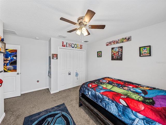 carpeted bedroom with a closet, a textured ceiling, and ceiling fan