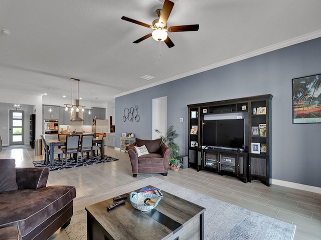 living room with crown molding and ceiling fan with notable chandelier