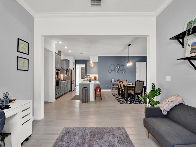 living room with crown molding and light hardwood / wood-style flooring