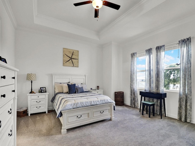 carpeted bedroom featuring ornamental molding, a tray ceiling, and ceiling fan