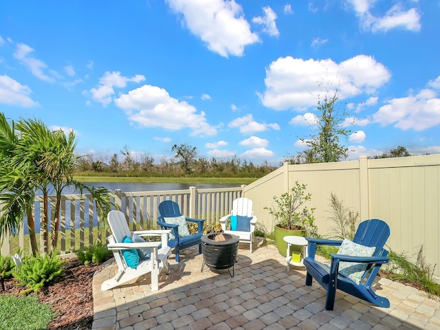 view of patio with a fire pit and a water view