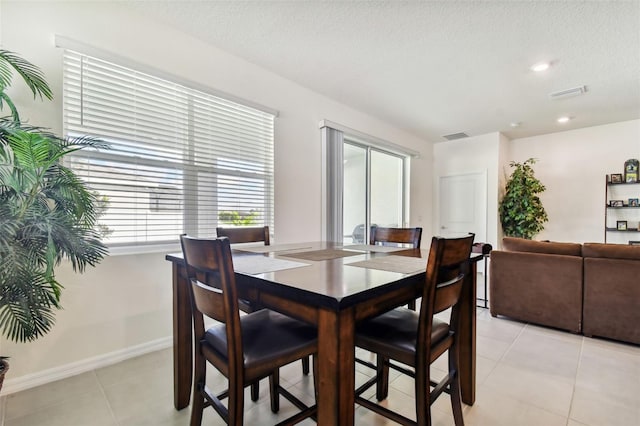 dining room with light tile patterned flooring and a textured ceiling