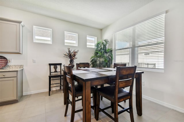 tiled dining room with a textured ceiling