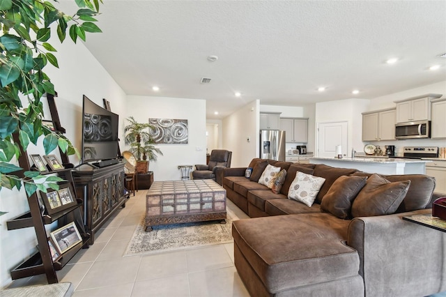 living room featuring a textured ceiling and light tile patterned floors