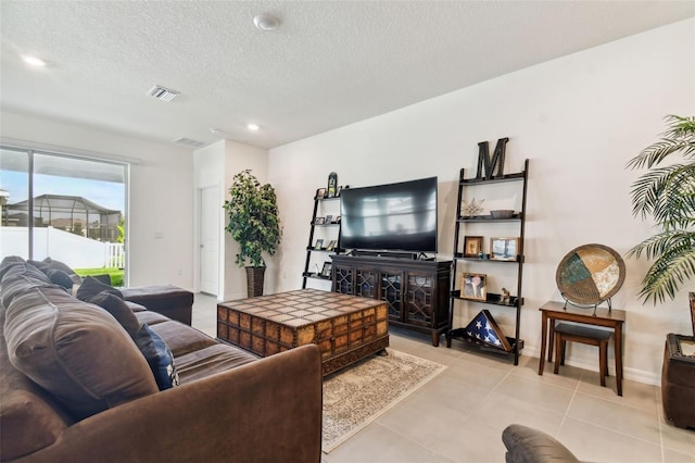 tiled living room featuring a textured ceiling