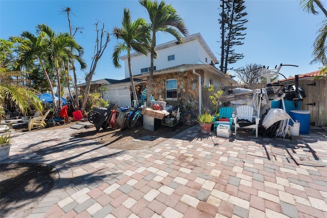 14180 W Parsley Dr, Madeira Beach, FL 33708 - exterior space with stone siding, a patio area, and fence