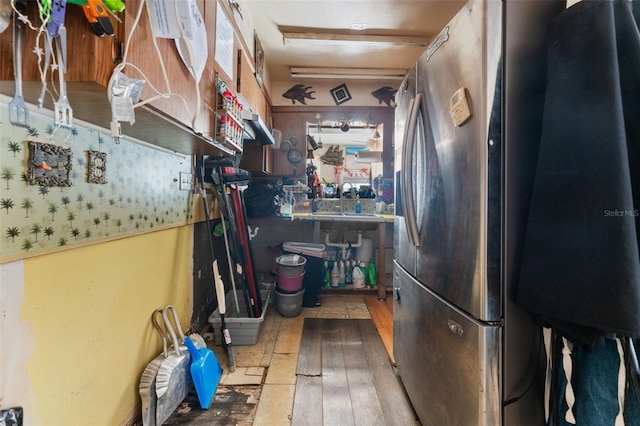 kitchen featuring wood-type flooring, sink, and stainless steel fridge