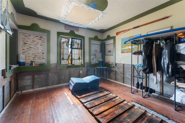 interior space featuring a textured ceiling and wood-type flooring