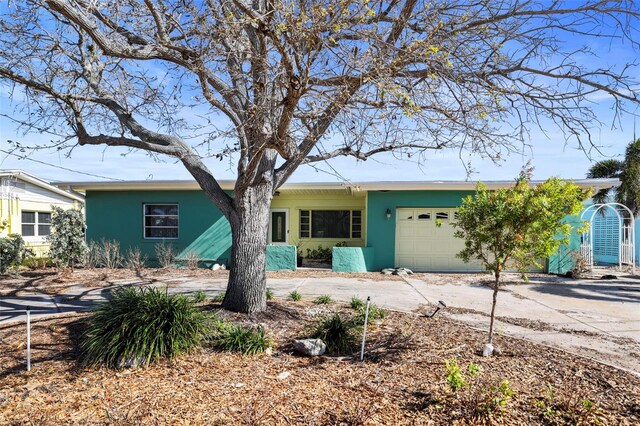 single story home featuring a garage, driveway, and stucco siding