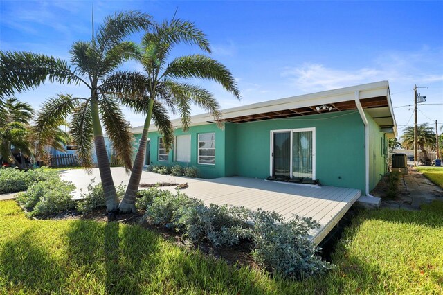 back of property with stucco siding and a deck