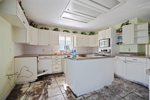 kitchen featuring white cabinets, a center island, stainless steel microwave, open shelves, and range