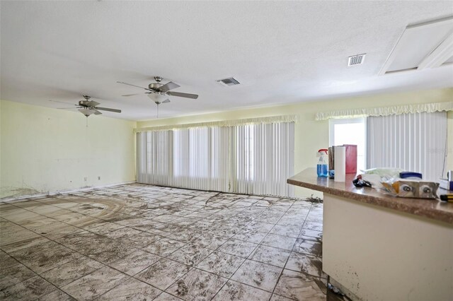 interior space with a textured ceiling and ceiling fan