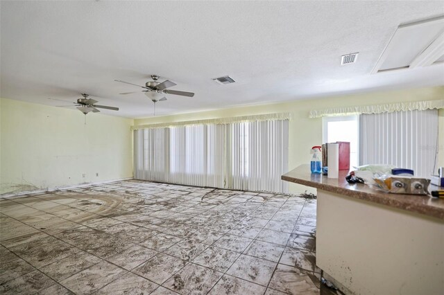 unfurnished living room featuring a ceiling fan and visible vents
