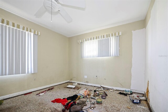 empty room with a ceiling fan and baseboards