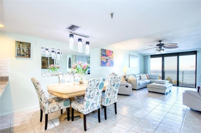 dining room featuring light tile patterned floors, ceiling fan, visible vents, and baseboards