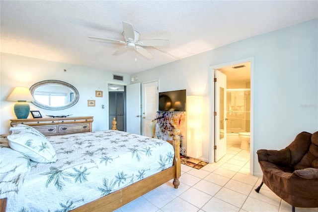 bedroom featuring light tile patterned floors, connected bathroom, visible vents, and a textured ceiling