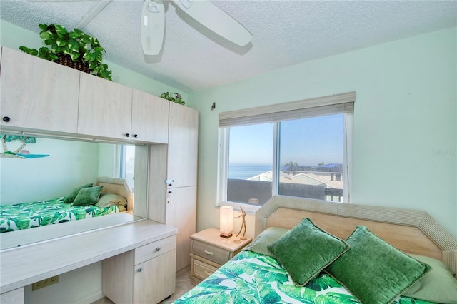 bedroom with ceiling fan and a textured ceiling