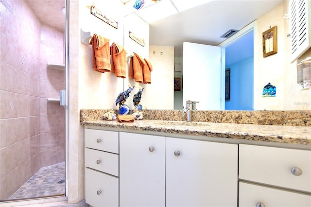 bathroom with visible vents, a stall shower, and vanity