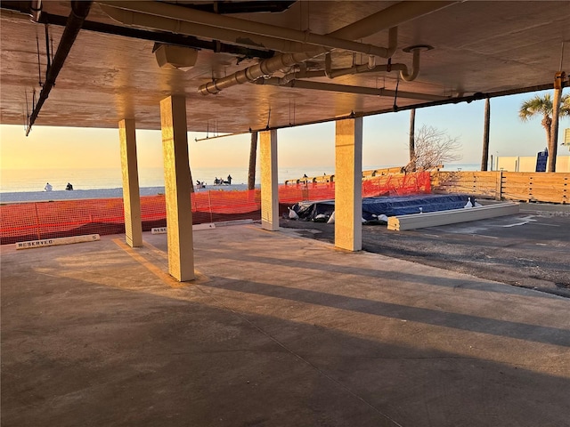 parking at dusk featuring a water view