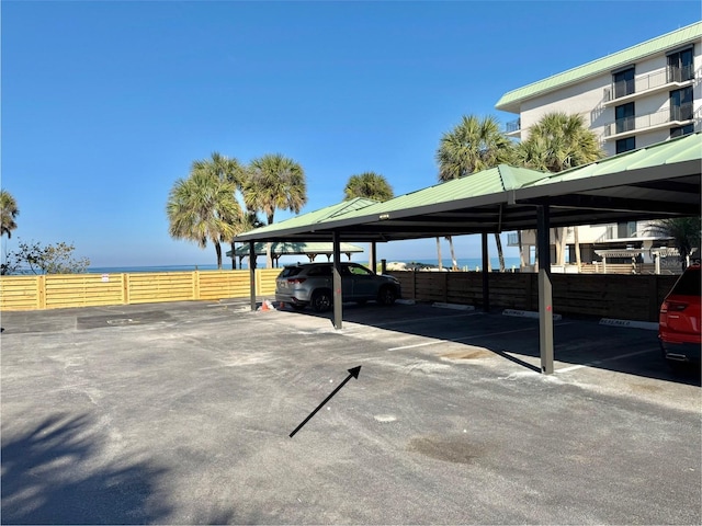 covered parking lot featuring fence