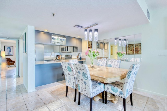 dining space featuring light tile patterned floors, baseboards, a textured ceiling, and recessed lighting