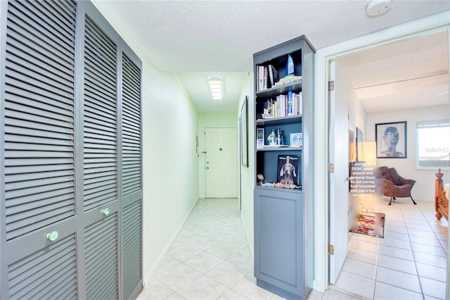hallway with light tile patterned floors, a heating unit, and a textured ceiling