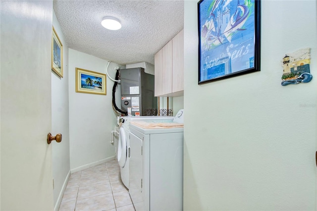 clothes washing area with cabinet space, a textured ceiling, light tile patterned floors, heating unit, and washer and dryer