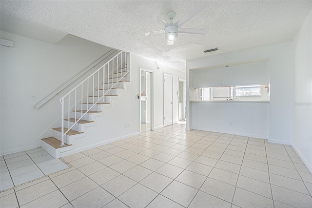 tiled spare room with ceiling fan and a textured ceiling