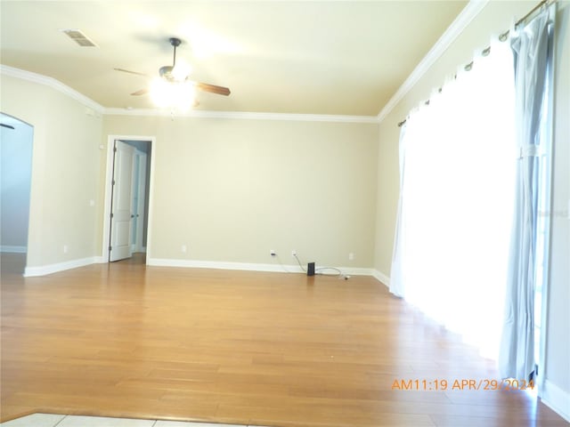 empty room with ornamental molding, light wood-type flooring, and ceiling fan