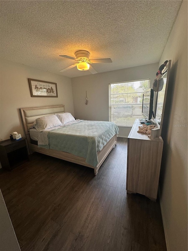 bedroom featuring a textured ceiling, dark hardwood / wood-style floors, and ceiling fan