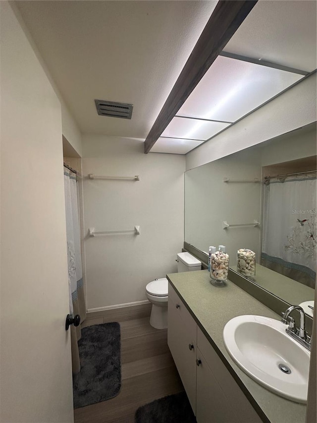 bathroom featuring vanity, toilet, a shower with shower curtain, and hardwood / wood-style floors