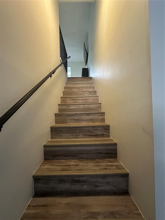 staircase with hardwood / wood-style flooring