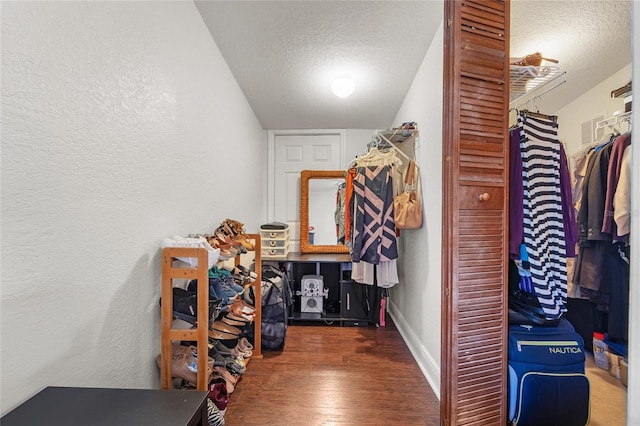 walk in closet featuring lofted ceiling and dark hardwood / wood-style floors