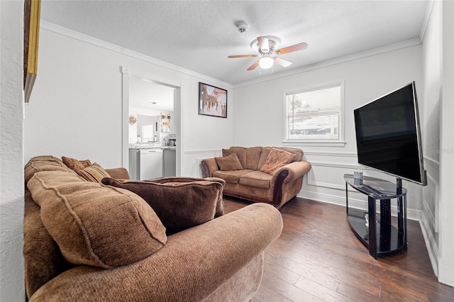 living room with dark wood-type flooring, crown molding, a textured ceiling, and ceiling fan