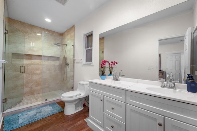 bathroom featuring vanity, toilet, an enclosed shower, and hardwood / wood-style floors