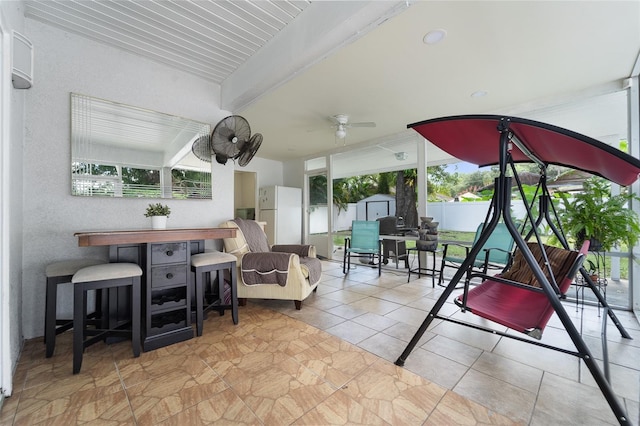 living room featuring ceiling fan and beam ceiling