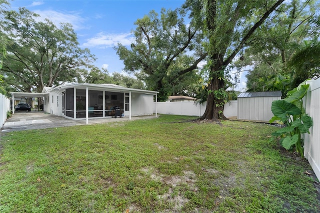 view of yard featuring a shed, a patio area, and a sunroom