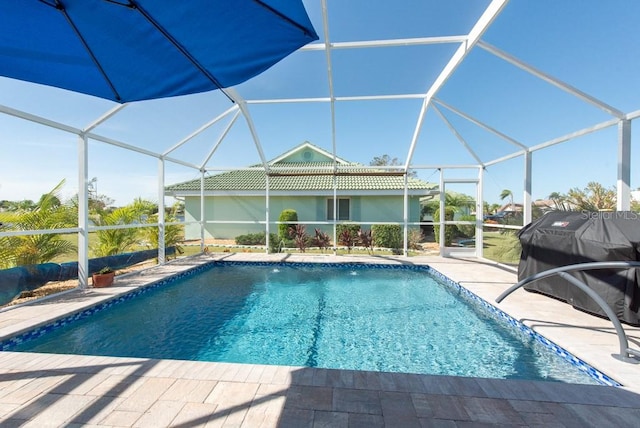 view of swimming pool with a patio area and a lanai