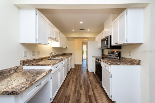 kitchen with dark hardwood / wood-style floors, dark stone counters, sink, white cabinetry, and appliances with stainless steel finishes