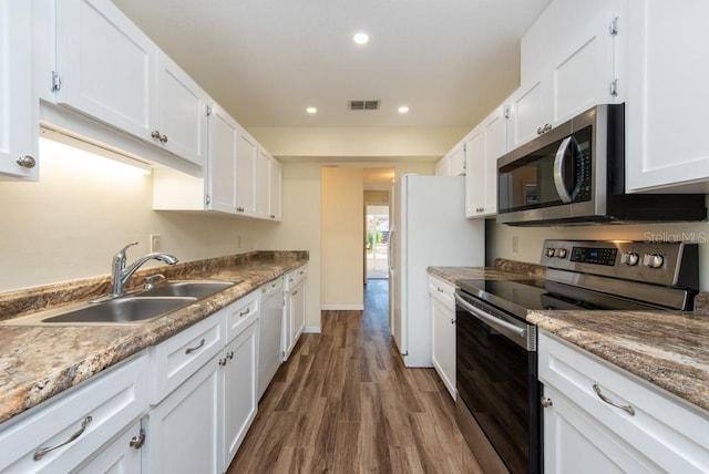 kitchen featuring dark wood-type flooring, appliances with stainless steel finishes, sink, and white cabinets